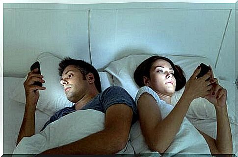 couple using cell phone in bed