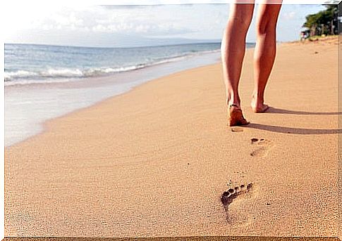 Beach travel - woman walking on sand beach closeup