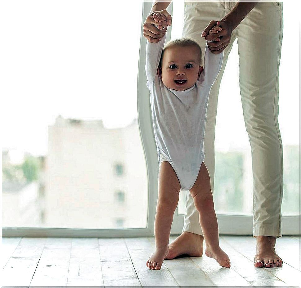 person helping baby to walk